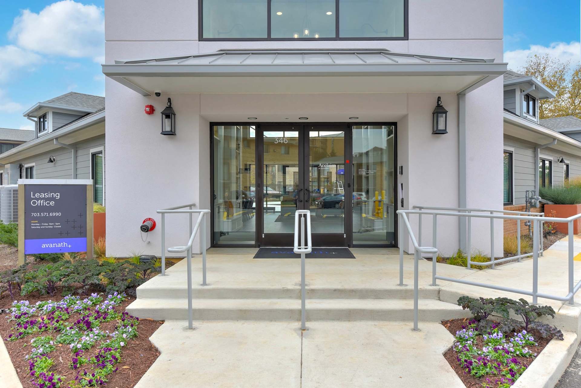 Exterior of the leasing office with concrete walkway.