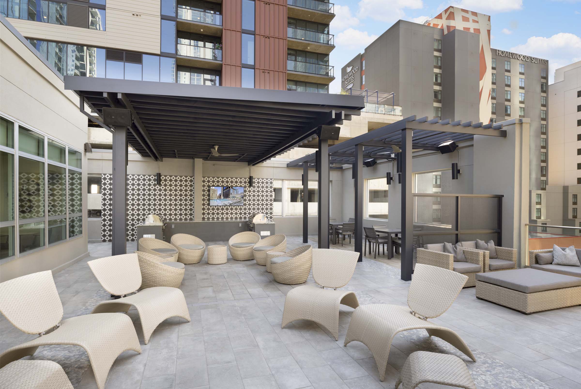 Rooftop poolside lounge with grills and covered seating at Camden Rainey Street apartments in Austin, TX