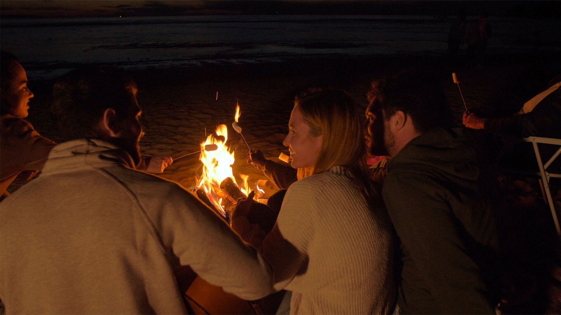 People surrounding a campfire at night