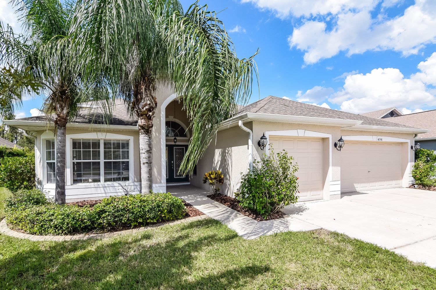 Front of house with three-car garage at Invitation Homes Tampa.