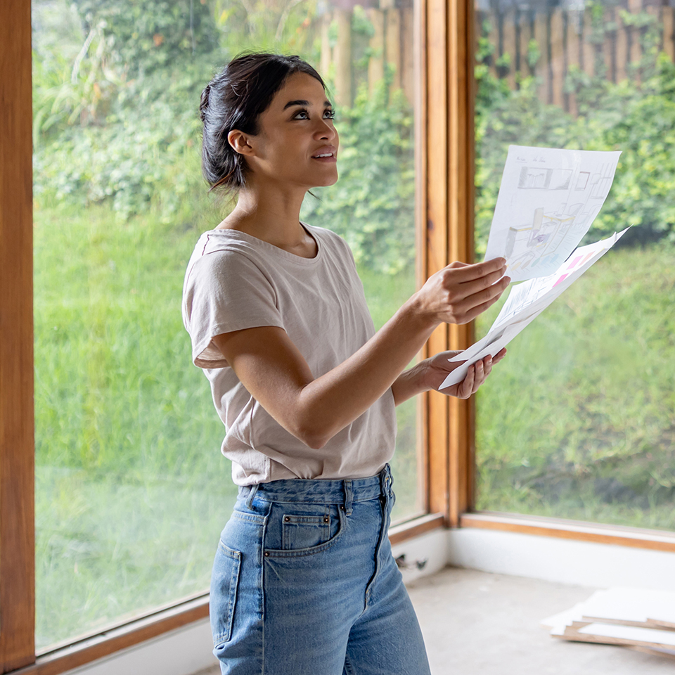 A woman holding up blueprints