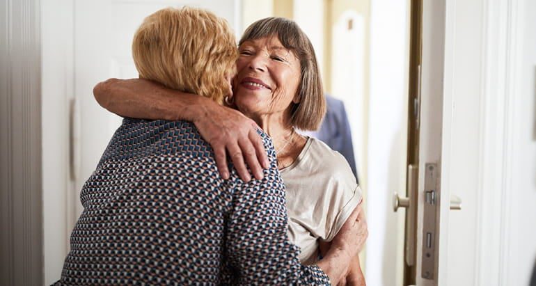 A woman hugs her friend who has Alzheimer's disease.