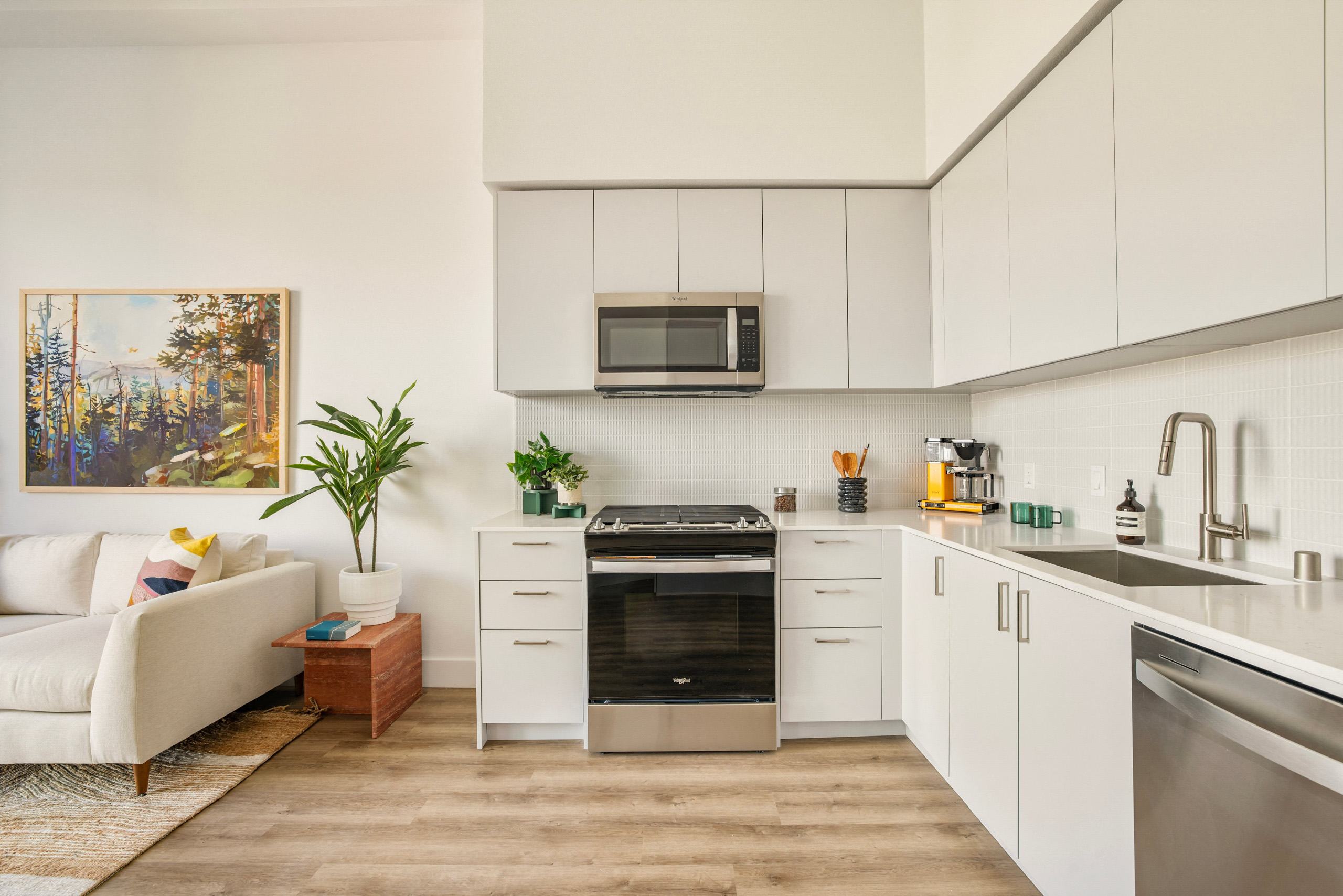 A modern kitchen with white cabinets and a stainless steel oven.
