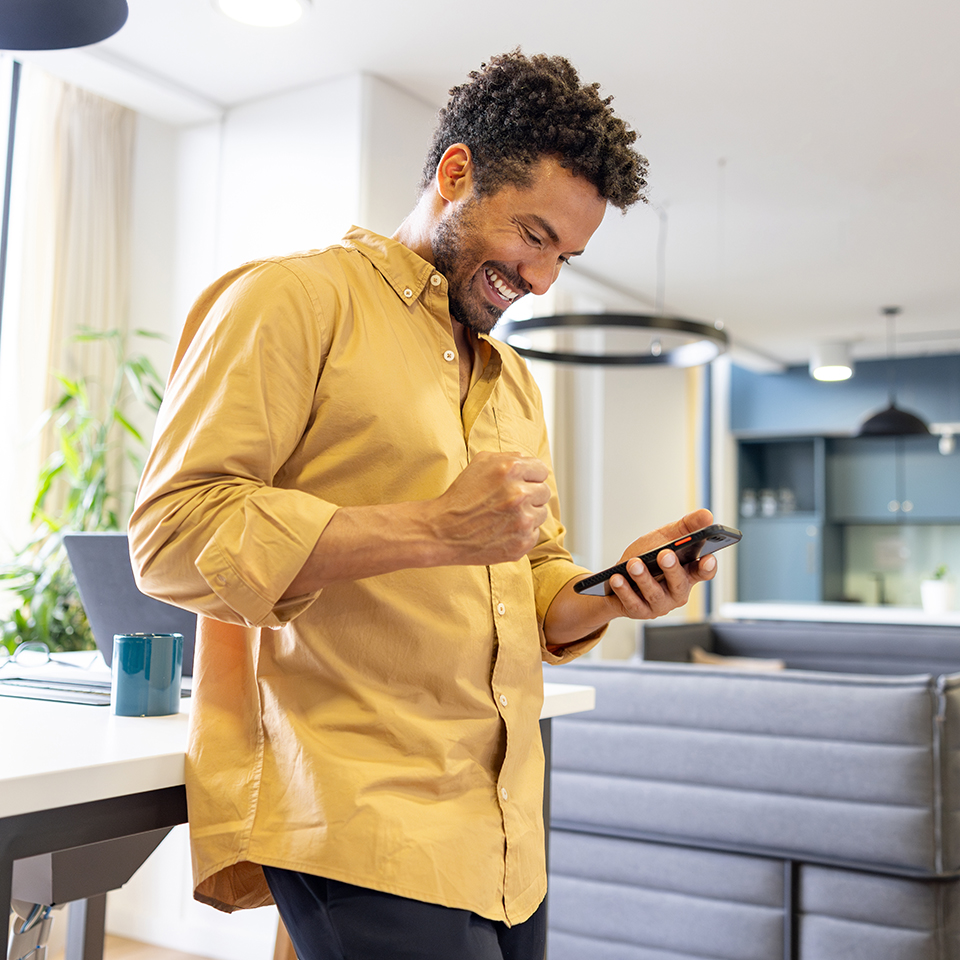 A happy man looking at a smartphone