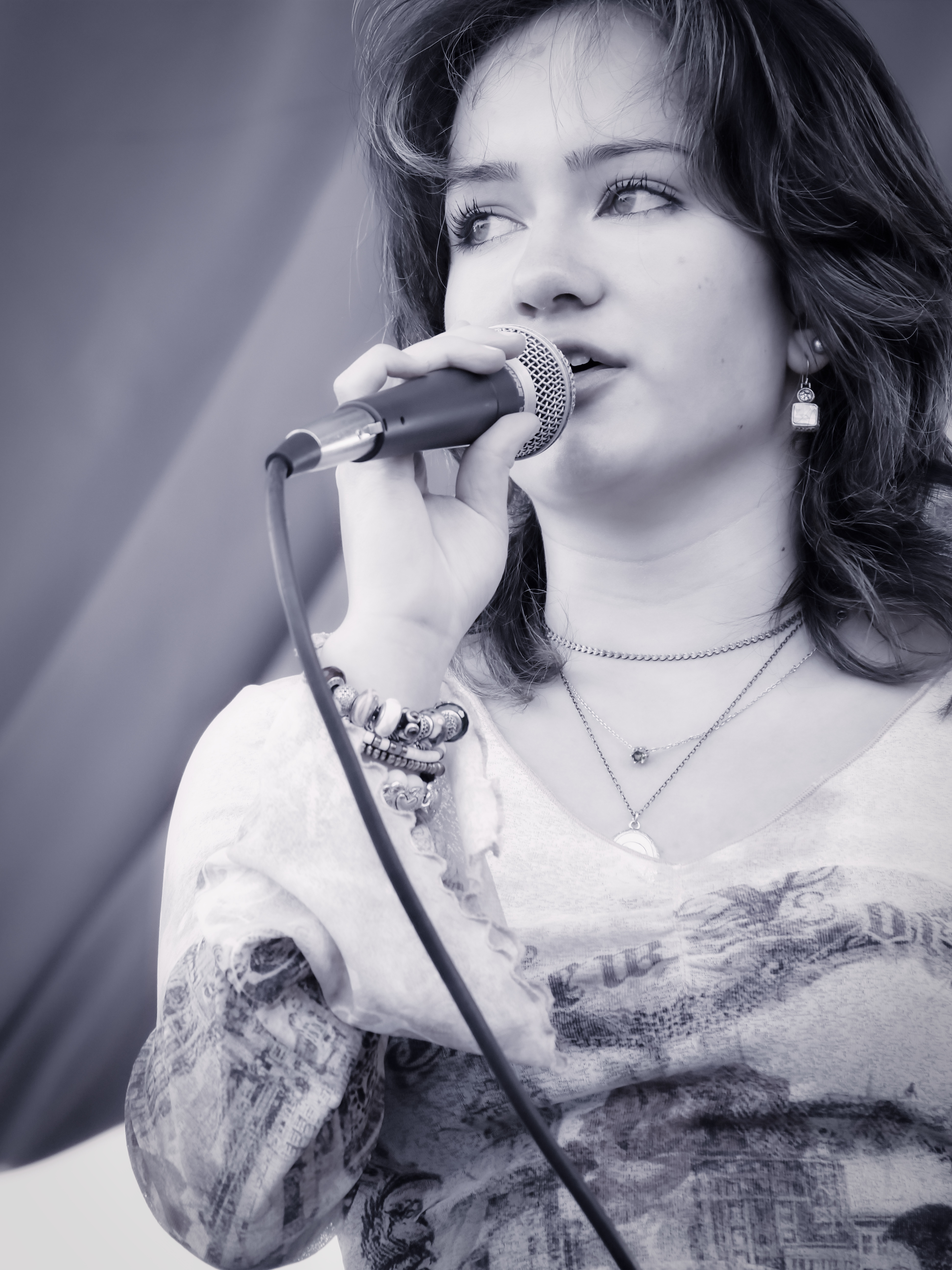 Black-and-white portrait of a student singer performing live during a vocal performance showcase.