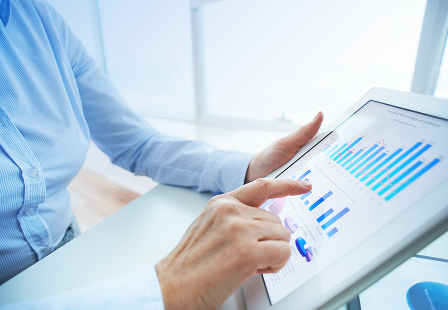 A person looking at charts on a tablet.