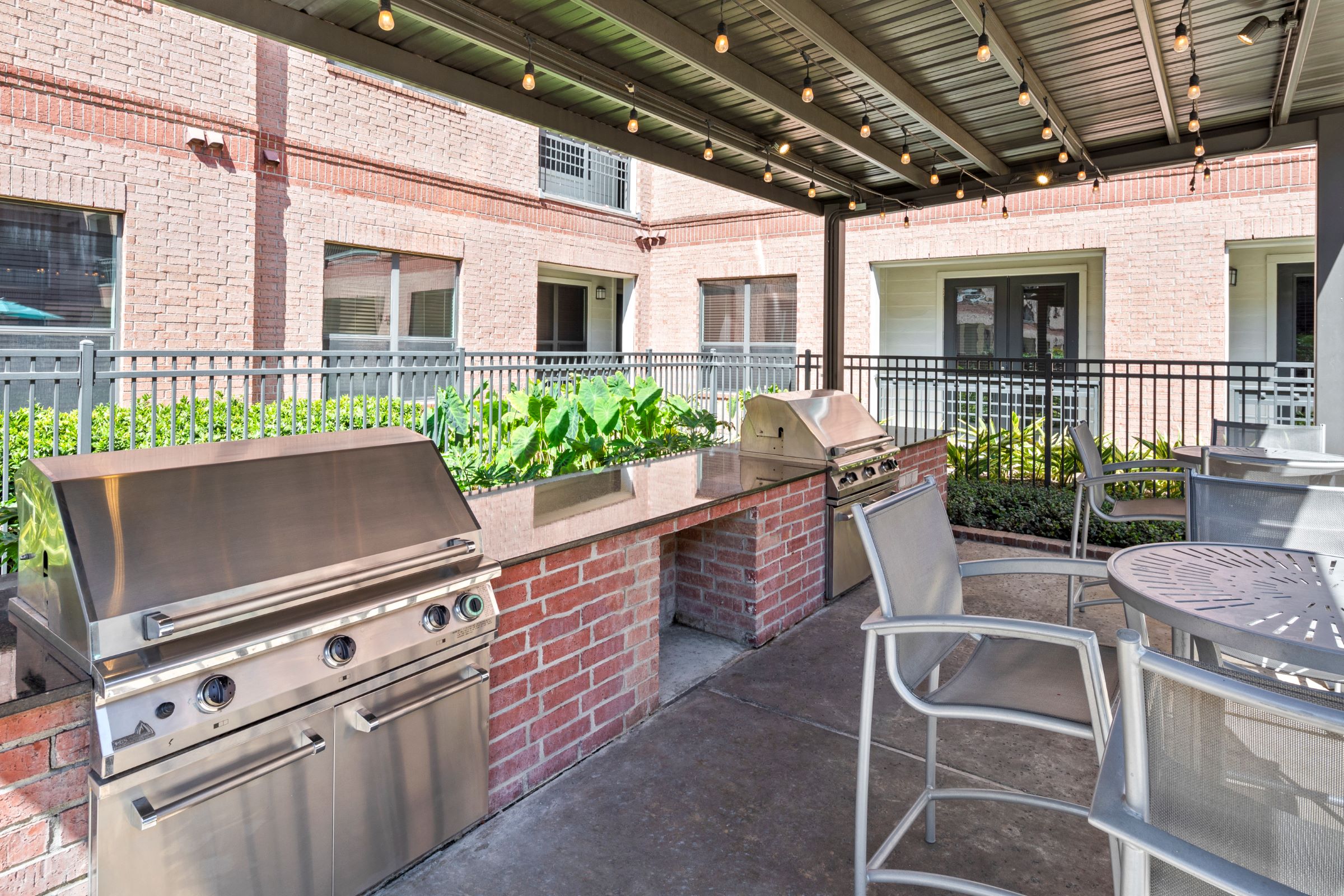 Outdoor grills with dining tables at Camden Travis Street Apartments in Midtown Houston, Tx