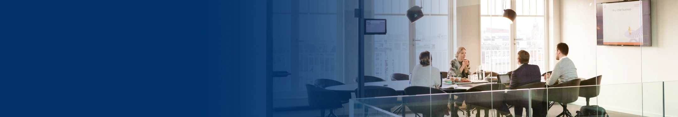Four people meeting in a board room.