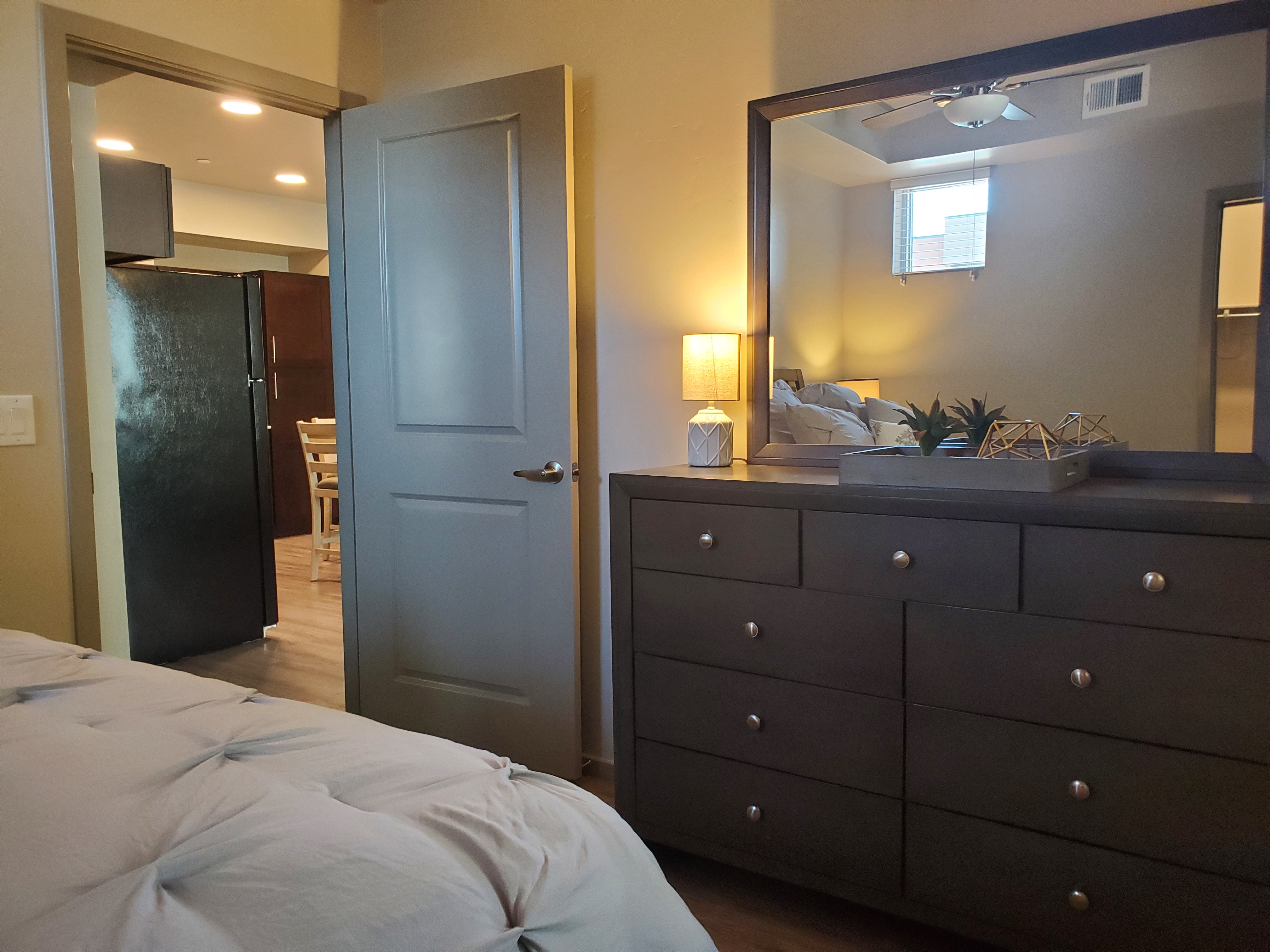 Bedroom with dresser and view to kitchen