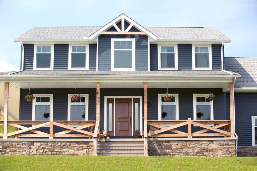 The EcoTek 3200 Series Windows enhance this home's bold exterior, providing a crisp, modern look that complements the deep blue siding and natural wood accents. These windows add style and energy efficiency to the facade, elevating the home's curb appeal.
