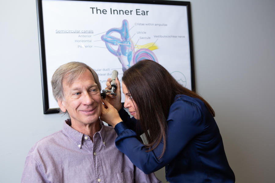 Meredith Wilken (Founder & Audiologist) conducts an ear exam