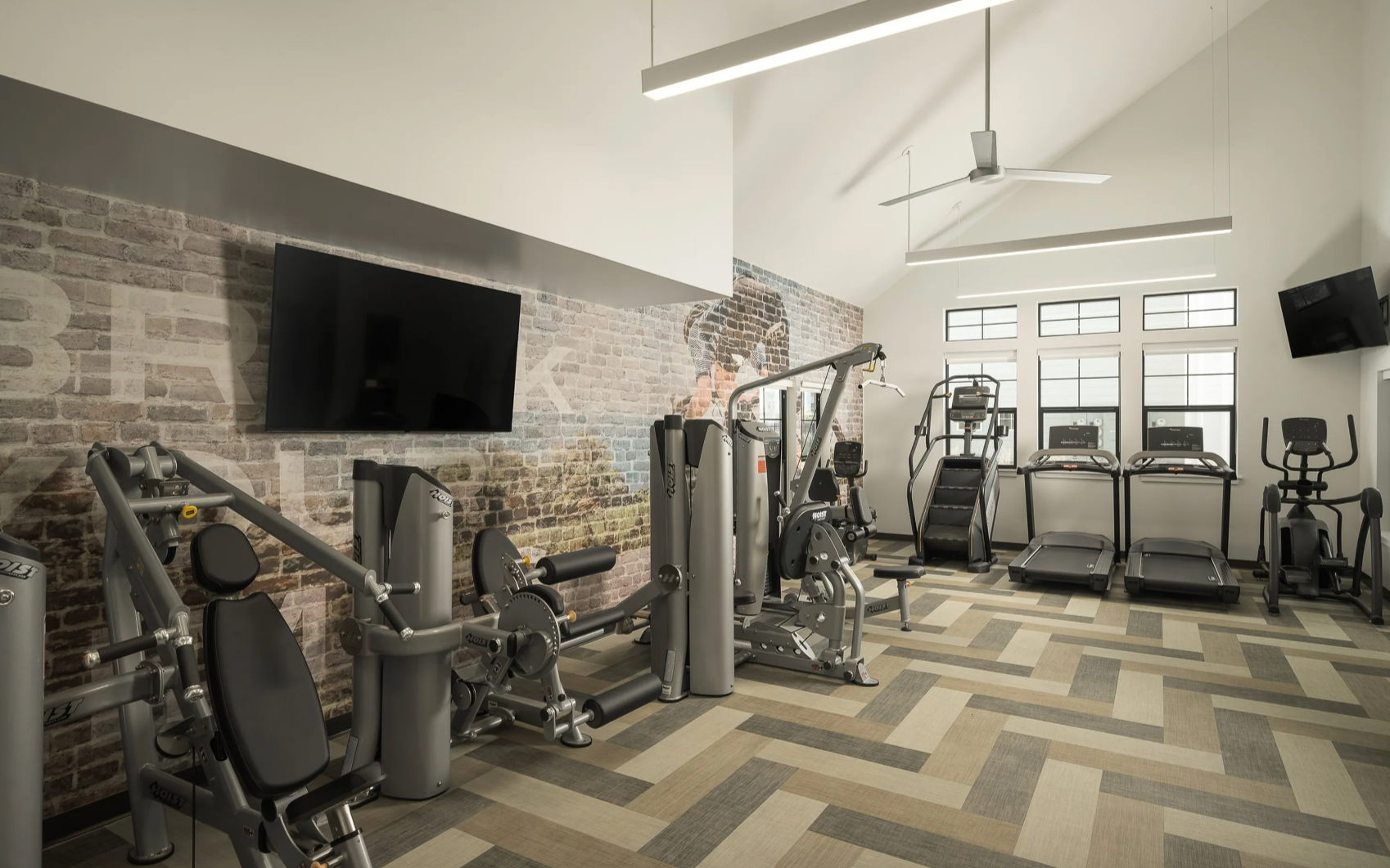 Fitness center with multiple cardio machines and free weights.