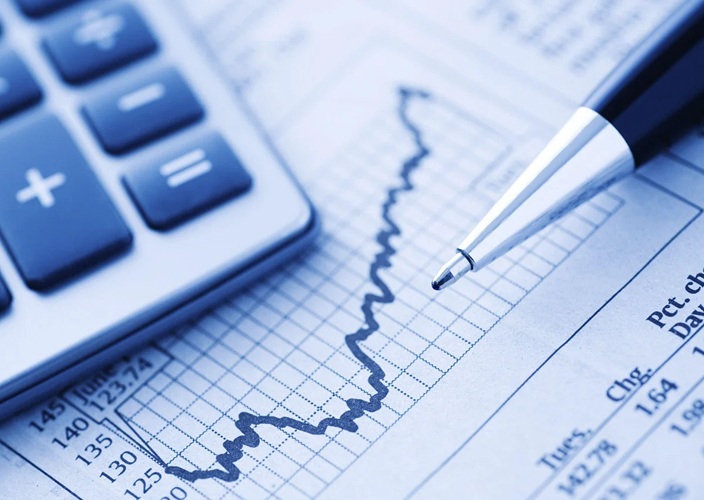 Close up of a pencil, calculator, and graph.