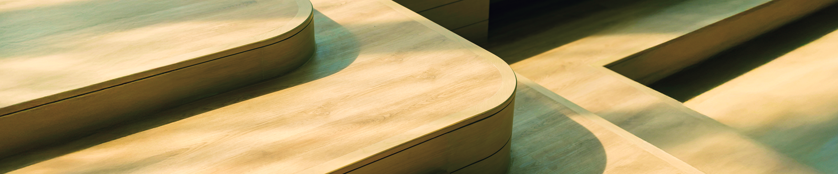 Dappled sunlight decorates wooden steps that have soft, curved edges.