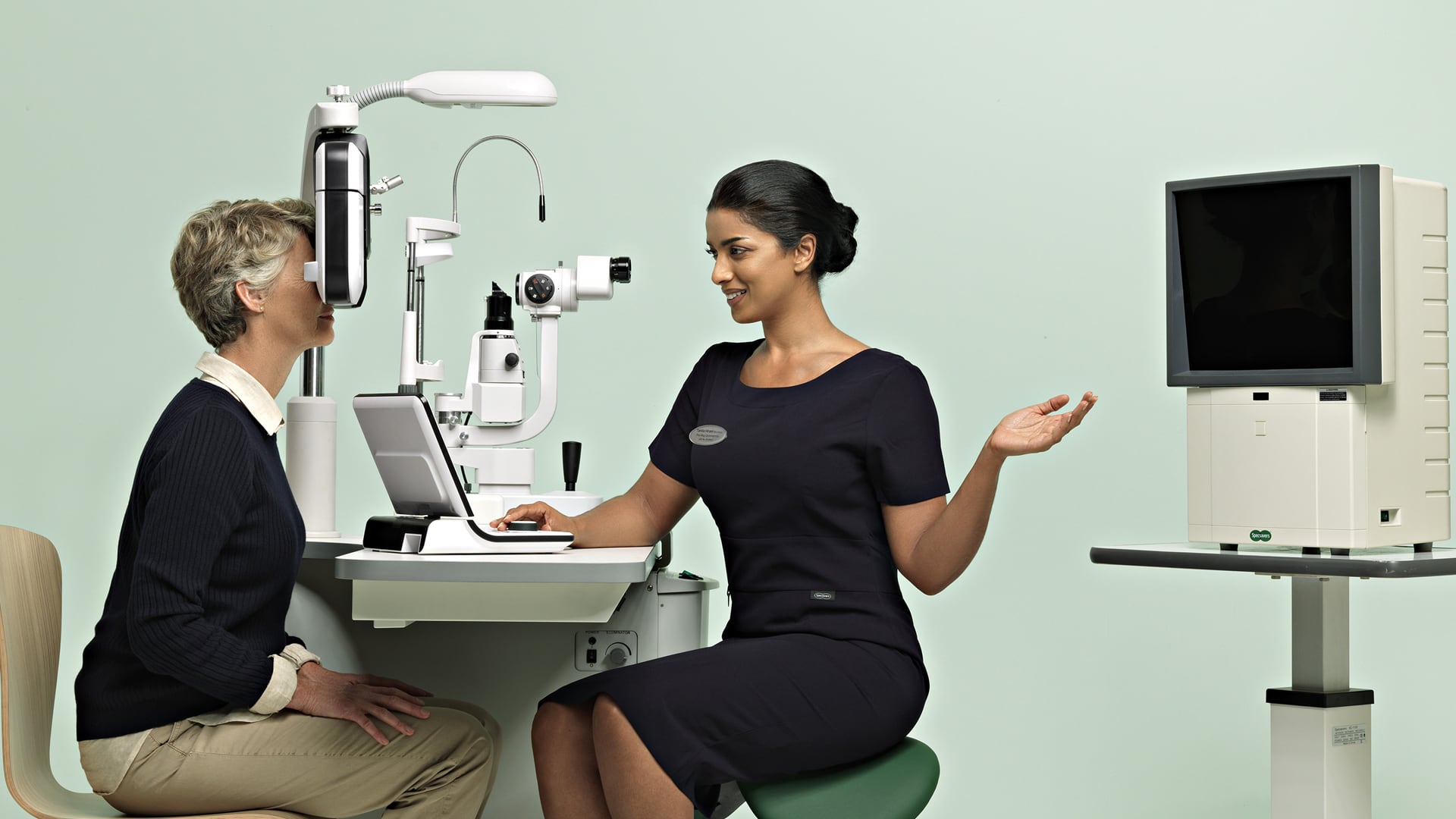 Un ophtalmologiste de Specsavers effectue un examen de routine sur un patient.