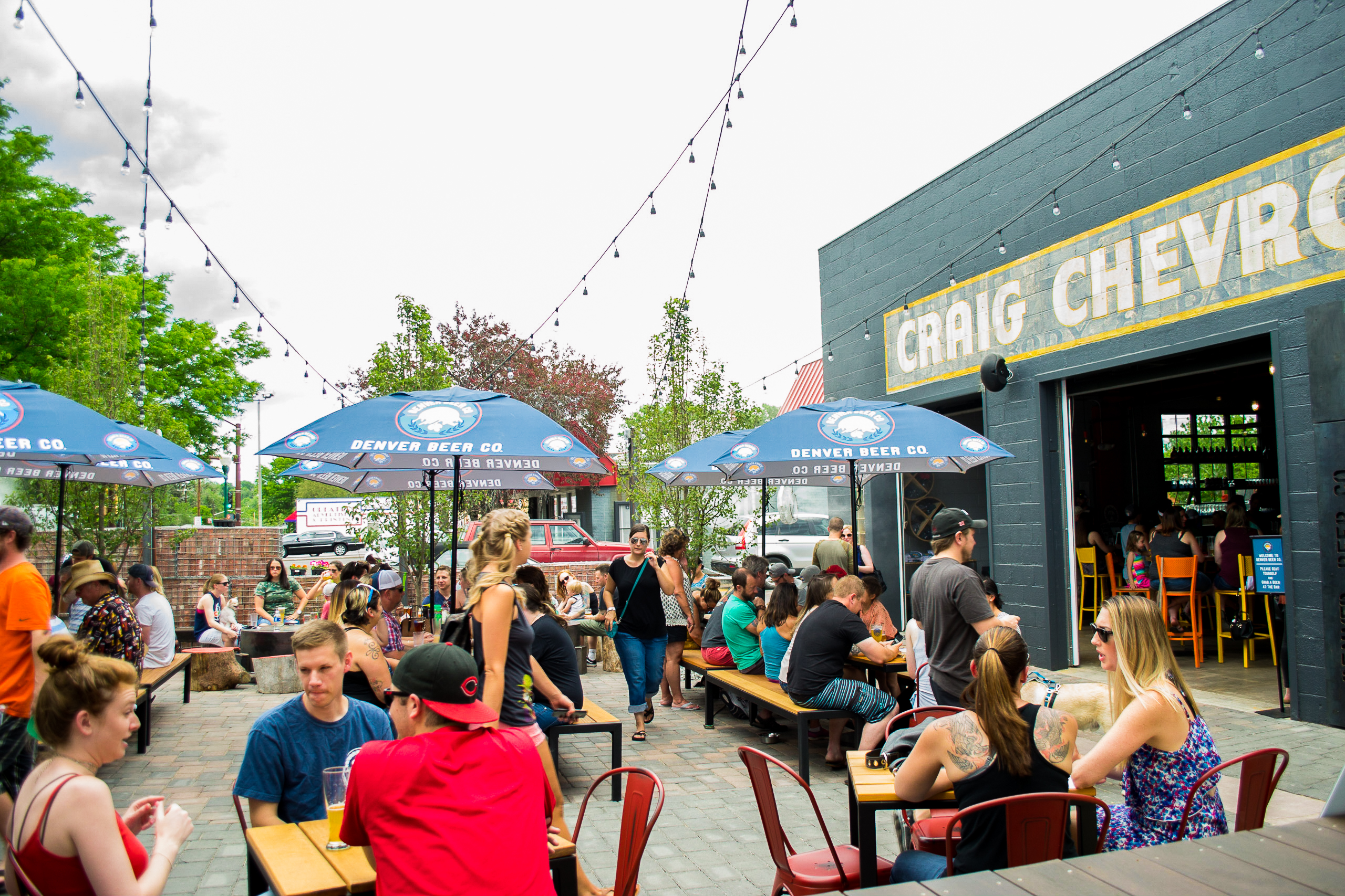 Guests enjoy craft beer and outdoor seating on the bustling patio at Denver Beer Co. Olde Town Arvada.