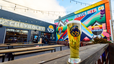 The outdoor patio at Denver Beer Co. Olde Town Arvada features community gathering spaces and colorful local artwork.