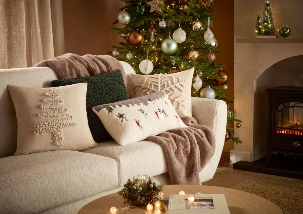 A sofa decorated with different styles and colours of Christmas cushions