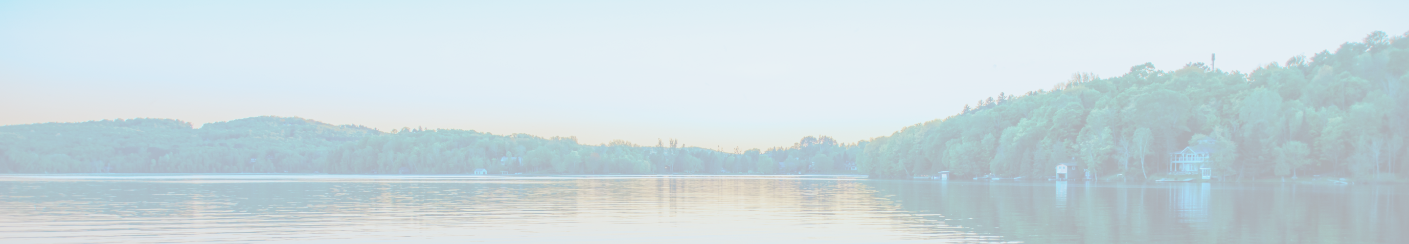 A lake surrounded by trees at sunset.