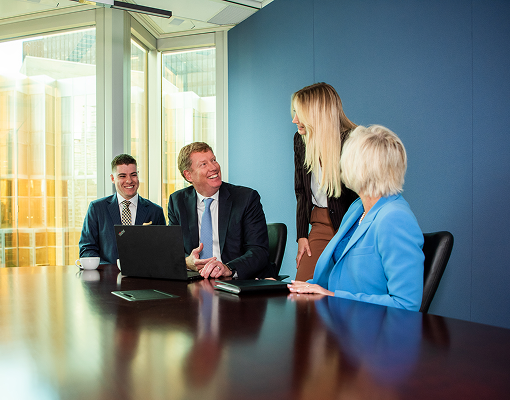 Chris Newall and team working at a boardroom table.