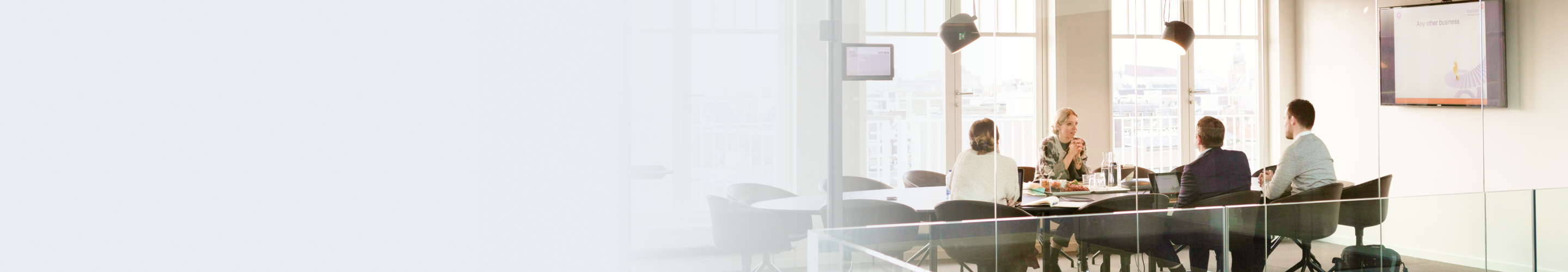 Four people meeting in a board room.