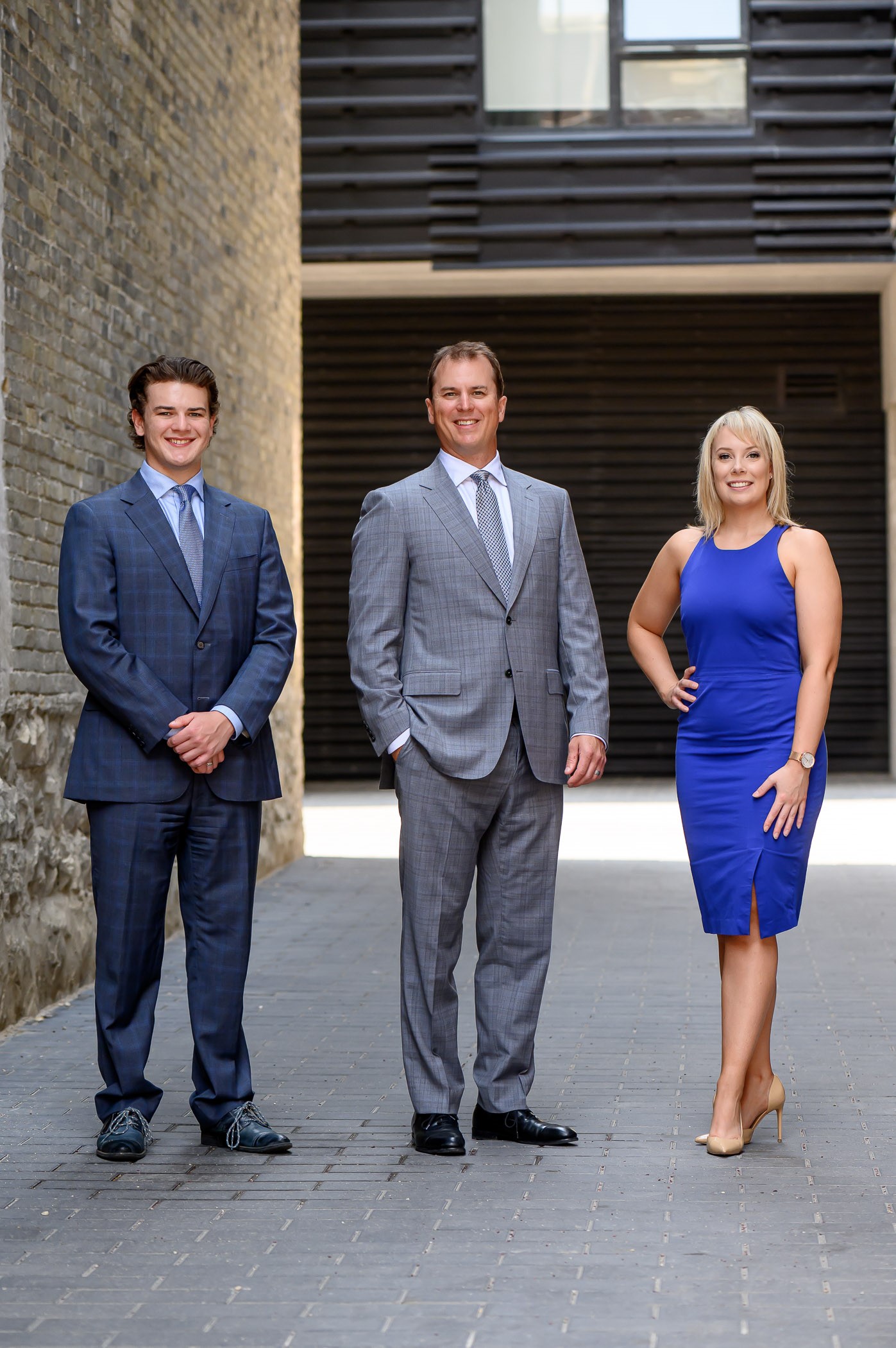 Carter (Left), Kevin (Middle), Emily (Right), standing in front of a brown and black building