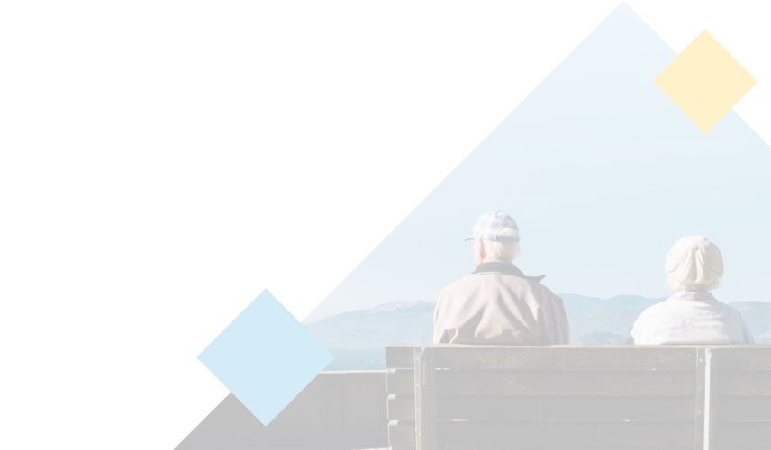An elderly couple sitting on a bench taking in the view of the mountains.