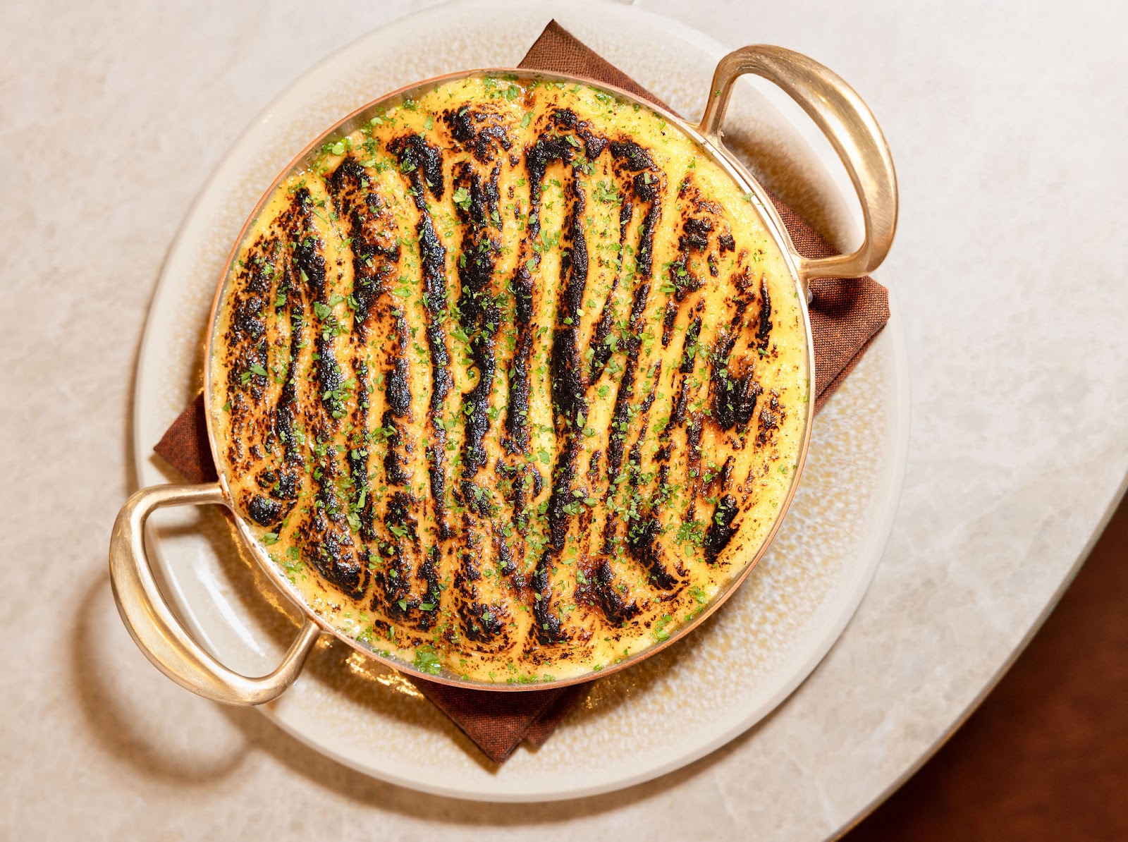 A baked seafood course from the Markette kitchen, plated for the table. Served in the dining room in Chelsea, Manhattan.