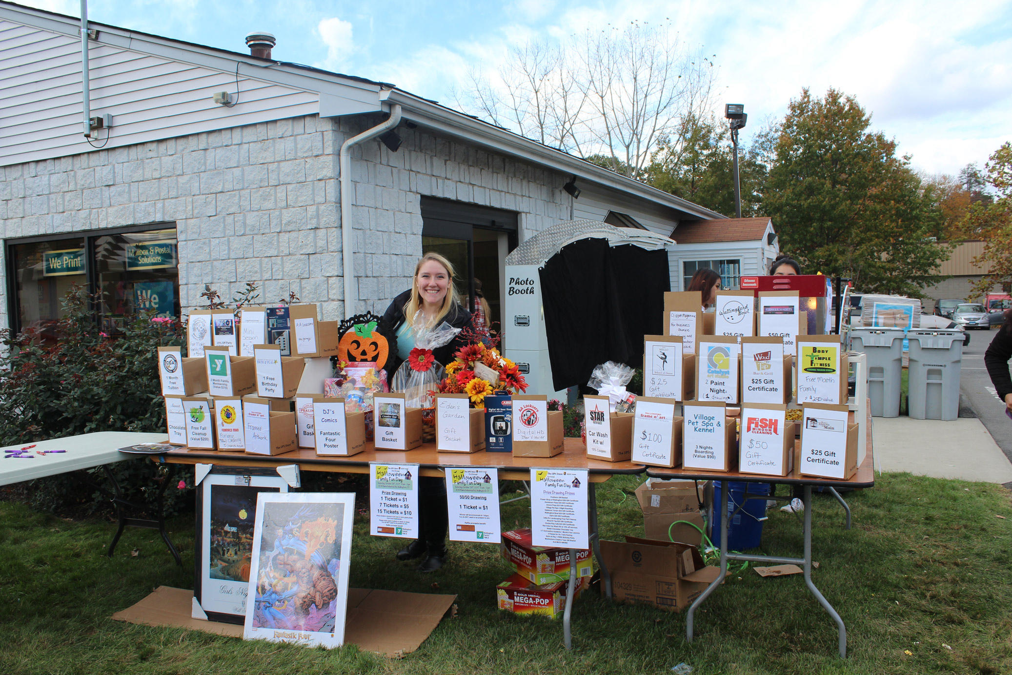 The UPS Store associate standing behind raffle prizes