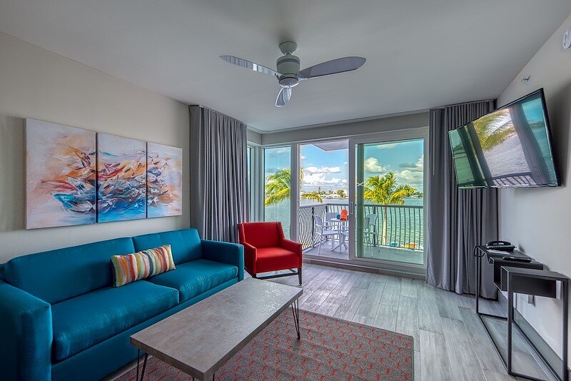 Modern waterfront suite living room with balcony access and intracoastal water views at FUSION Resort in Treasure Island, Florida.
