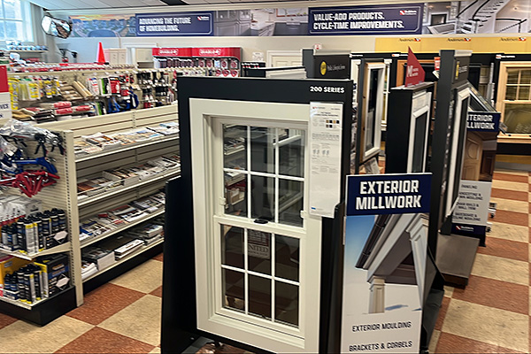 Interior of Builders FirstSource New Bedford store showing window and exterior millwork displays, including exterior molding samples and home improvement products.