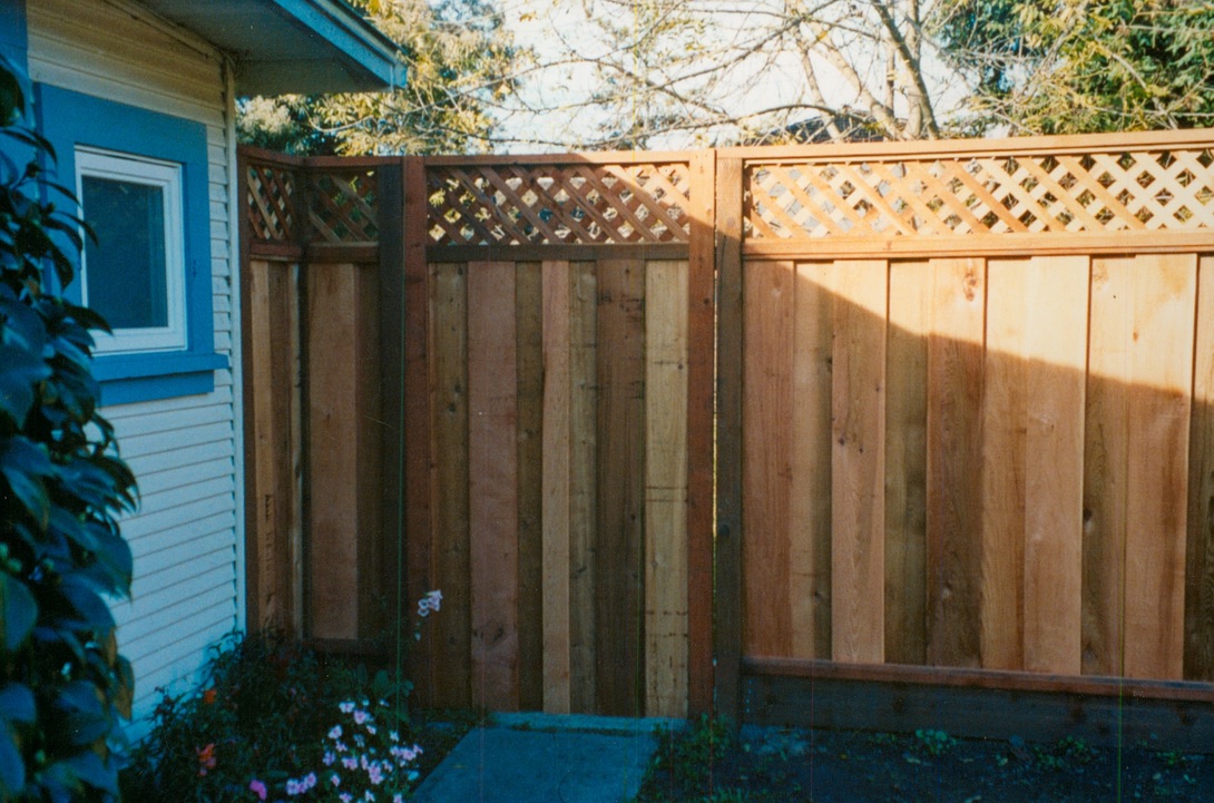 Wood privacy fence with decorative lattice trim, adding security and a finished look to the backyard.