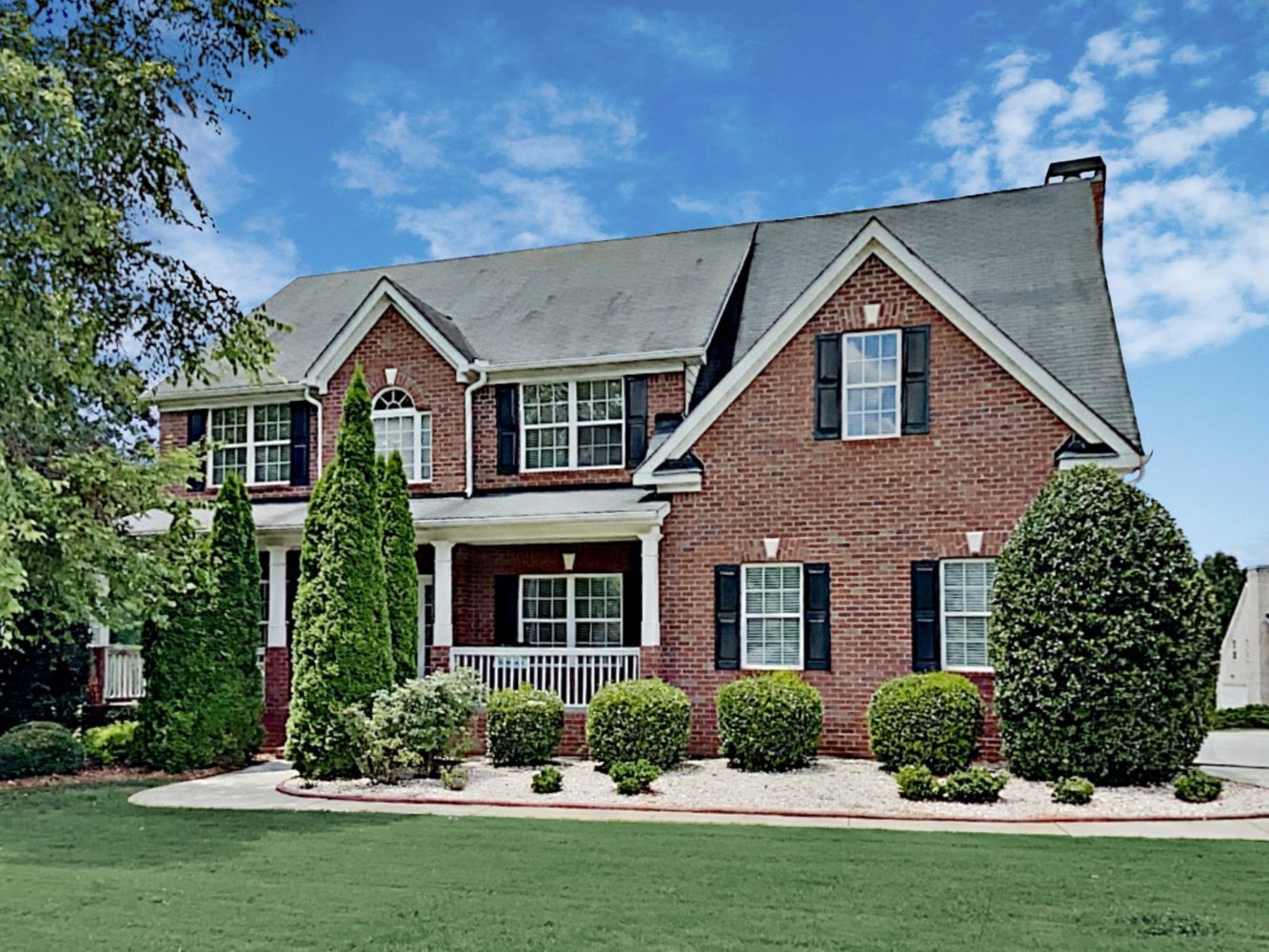 Classic brick home with front porch and beautiful landscaping at Invitation Homes Atlanta.