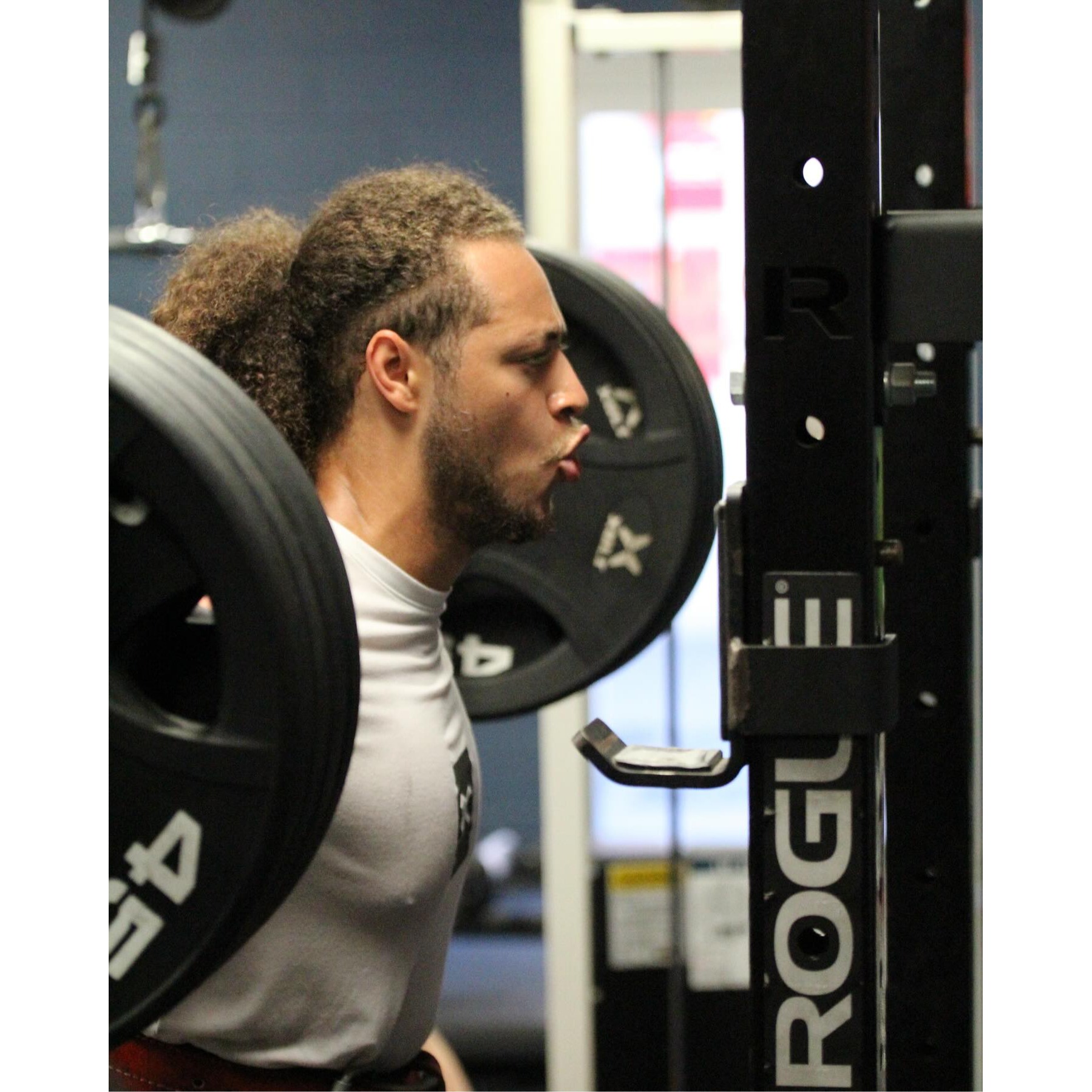 Male athlete performing back squat during strength training at Impact Sports Performance