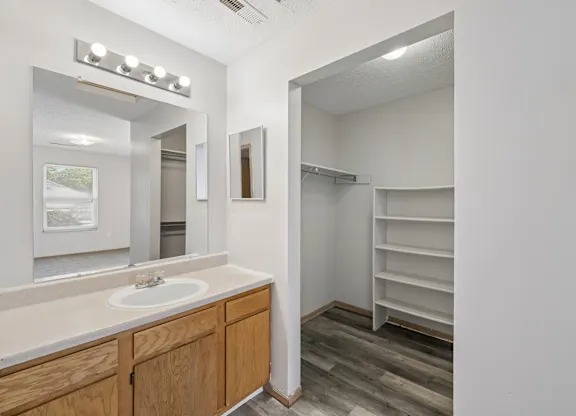 A bathroom with a sink, mirror, and shelves. 