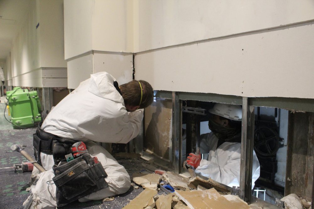 Technicians performing flood cuts to the drywall in every affected room at the commercial building.