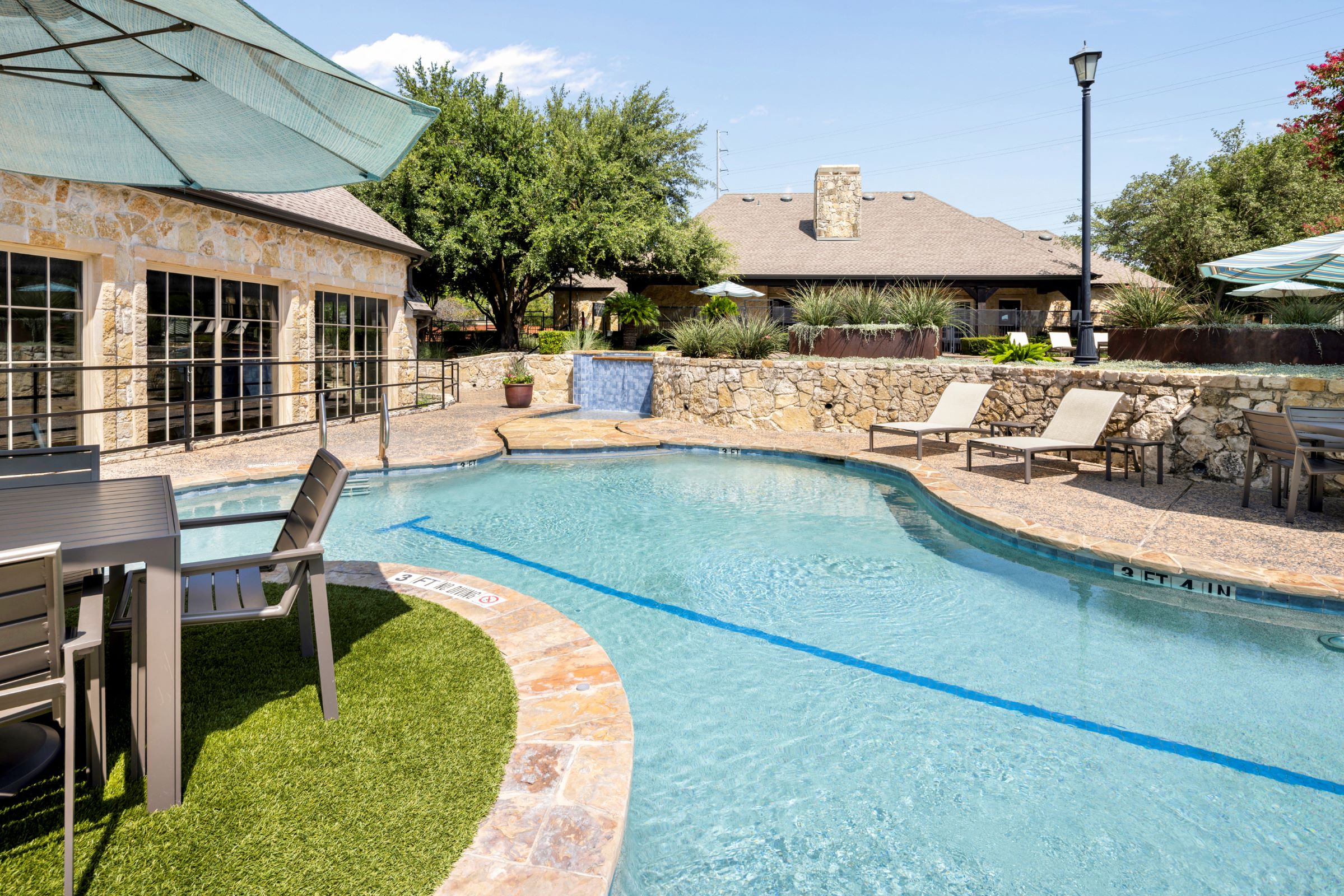 Lower level of resort-style pool with seating at Camden Shadow Brook apartments in Austin, TX 