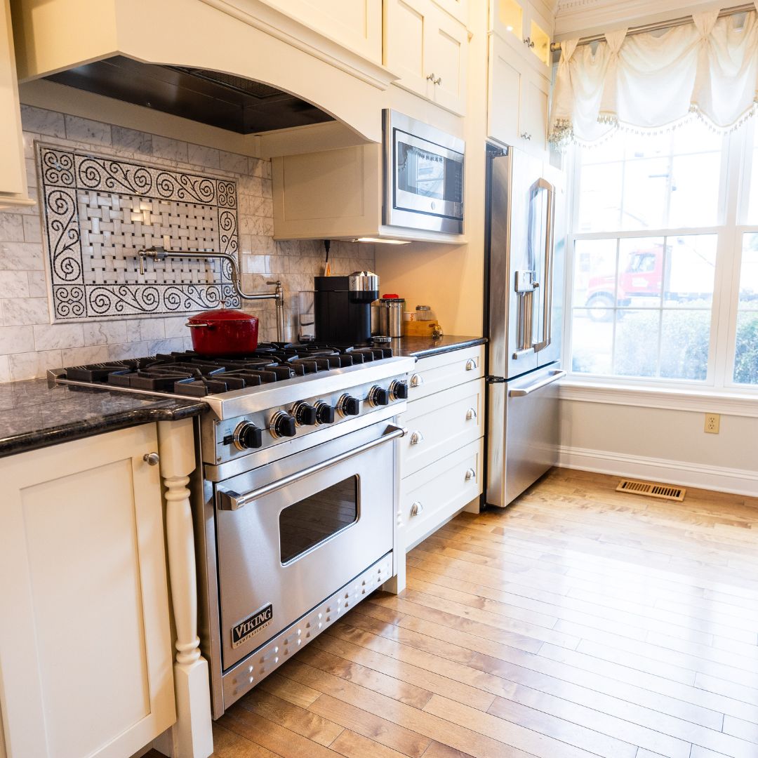 Stainless steel Viking range set against a decorative mosaic backsplash and custom cabinets.