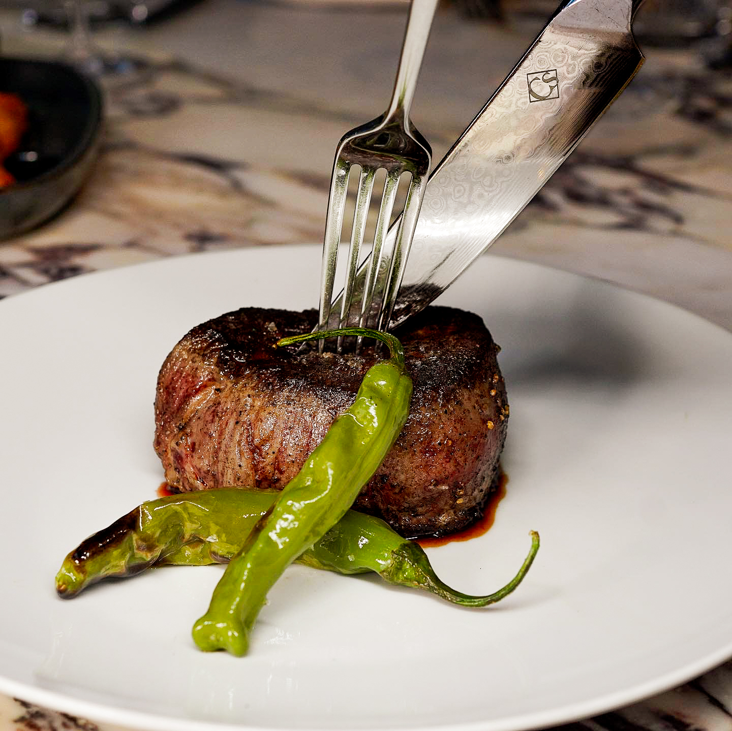 Grilled filet mignon served with shishito peppers at Carversteak NYC.