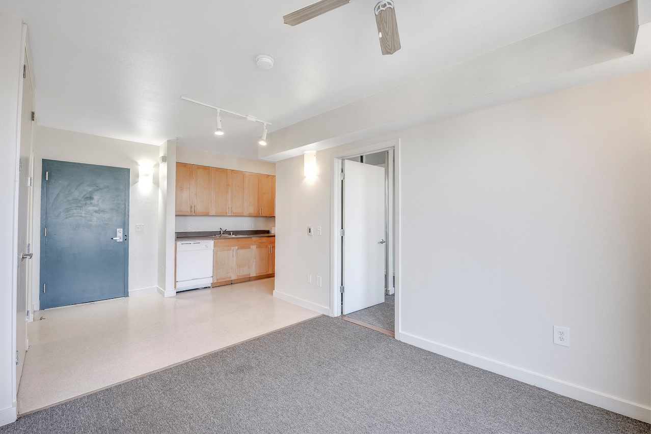 A spacious living room with a kitchen in the background. 