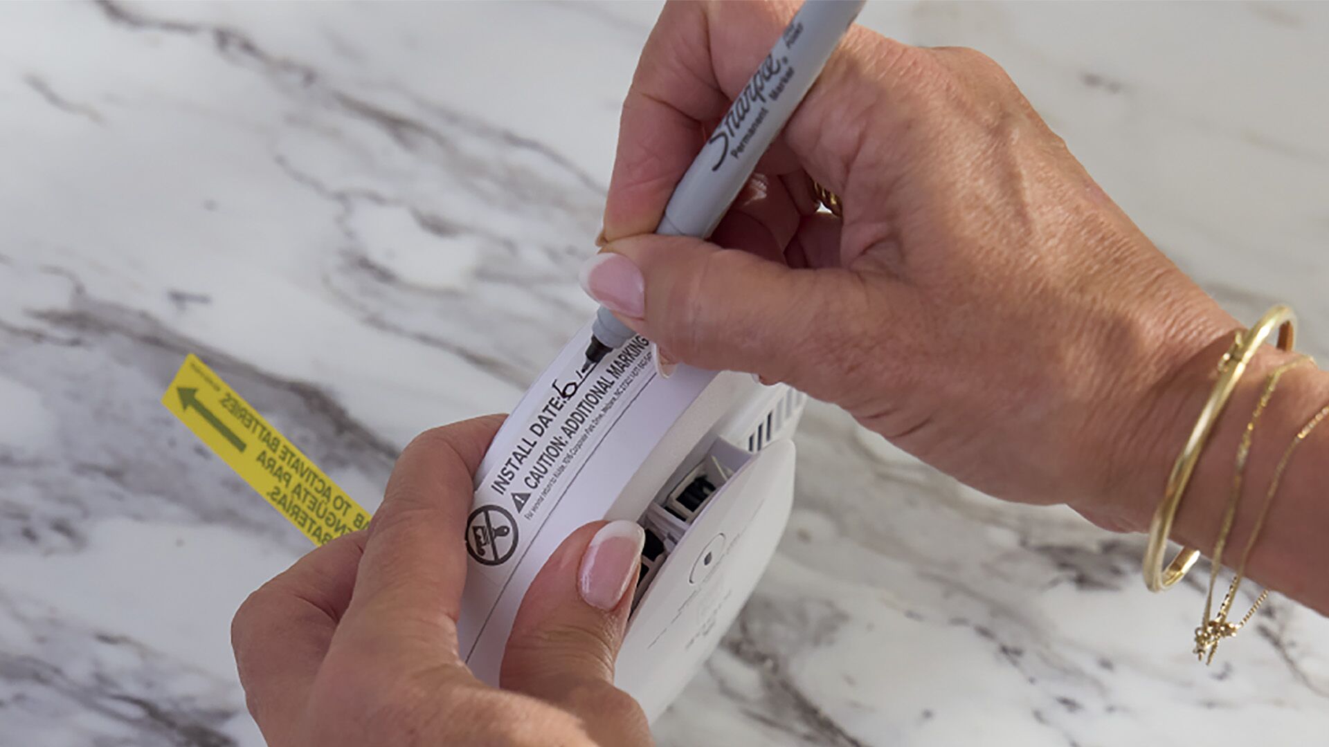 woman making note of the date of installation of a safety device