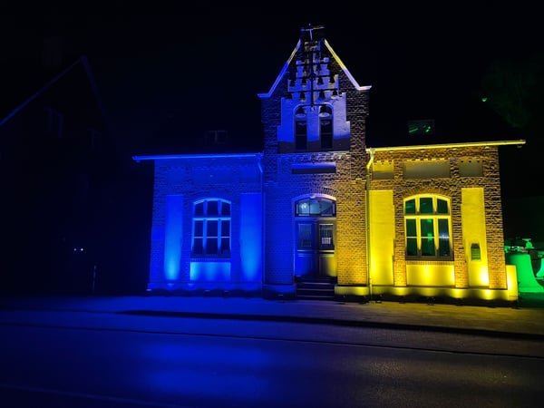 GPM Entertainment - DJ Münster Architektonische Außenbeleuchtung Münster: Hausfassade in Blau und Gelb illuminiert – perfekte Ambientebeleuchtung für Events und Sonderveranstaltungen.