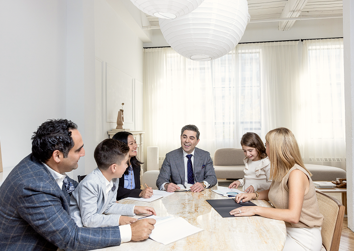 The Naman Private Wealth team meeting with a client family to review documents.