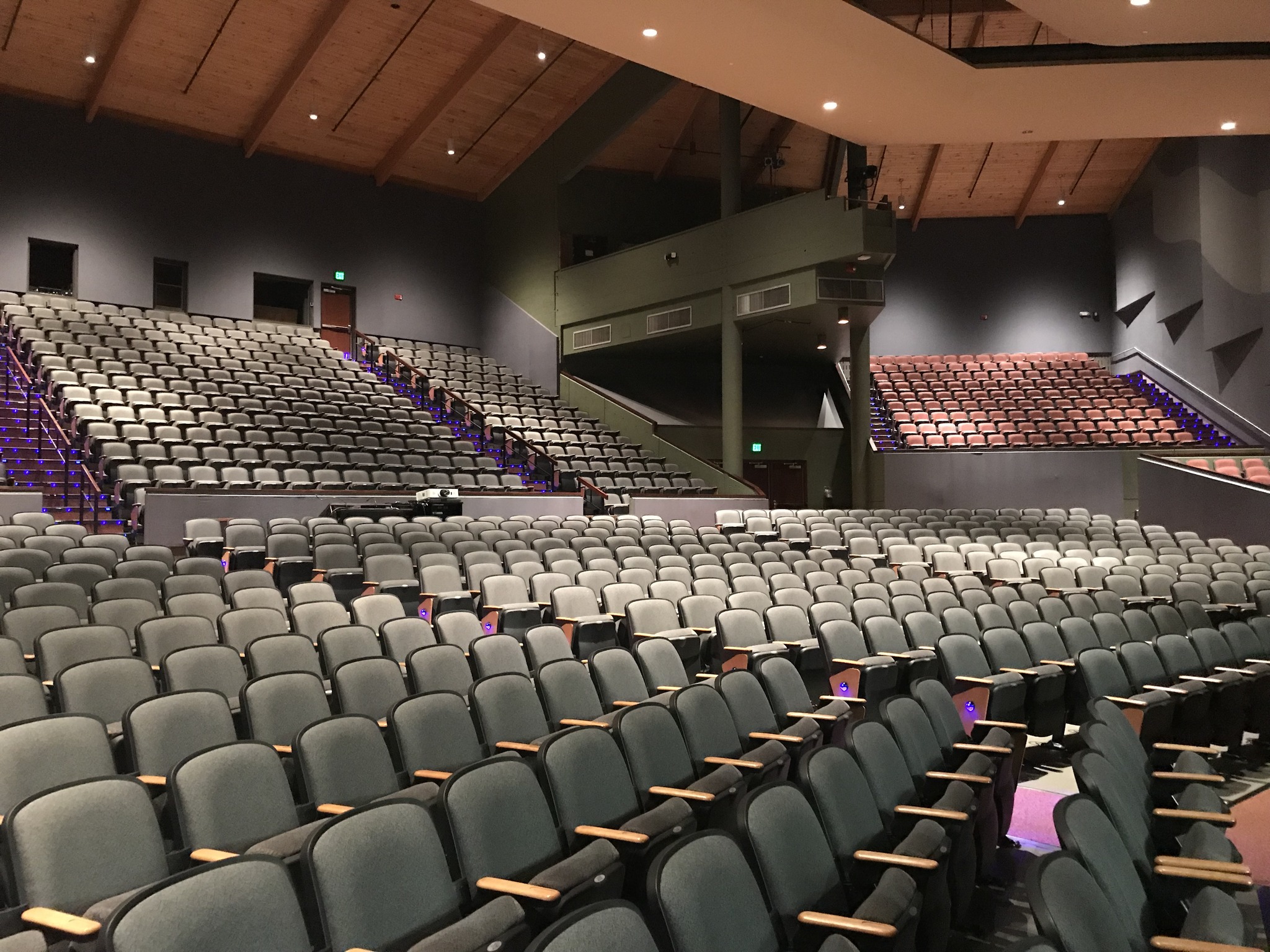 The Lincoln Center Performance Hall renovation was updated in celebration of their 40 year anniversary. The renovation project included removing the seats that were original to the 1978 opening of the facility and replacing them with modern theater seats with cup holders. The project also included new carpet and epoxy concrete flooring and new light lock vestibule construction on the mezzanine. In addition, a custom design-built audio/visual cable management system and modern LED egress aisle lighting system was installed.