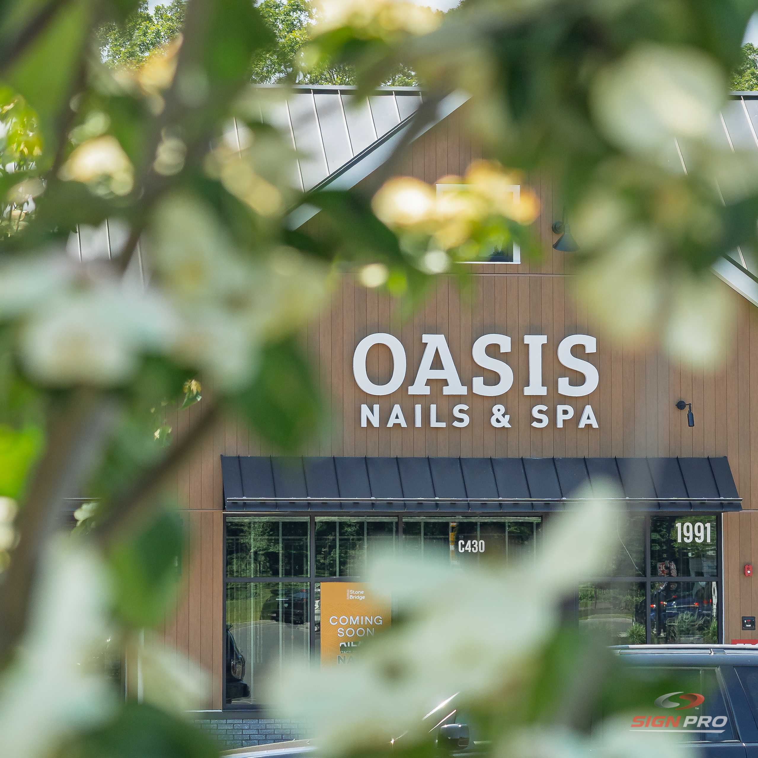 Custom storefront channel letter signage fabricated and installed by Sign Pro for Oasis Nails & Spa, creating an elegant and professional business presence.