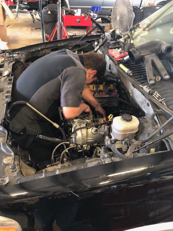 C H Auto Repair mechanics working on a vehicle.