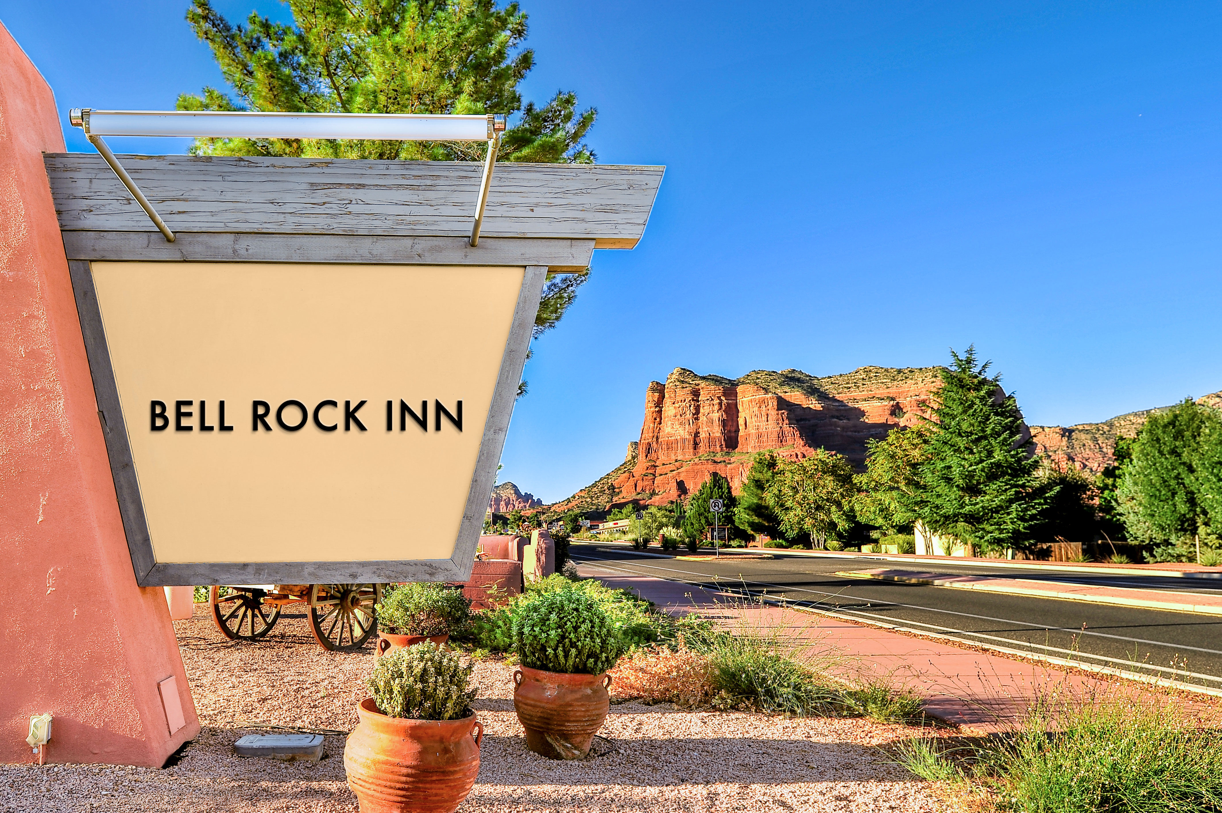 The front sign for Bell Rock Inn. The red rocks of Sedona, Arizona are prominently displayed nearby.