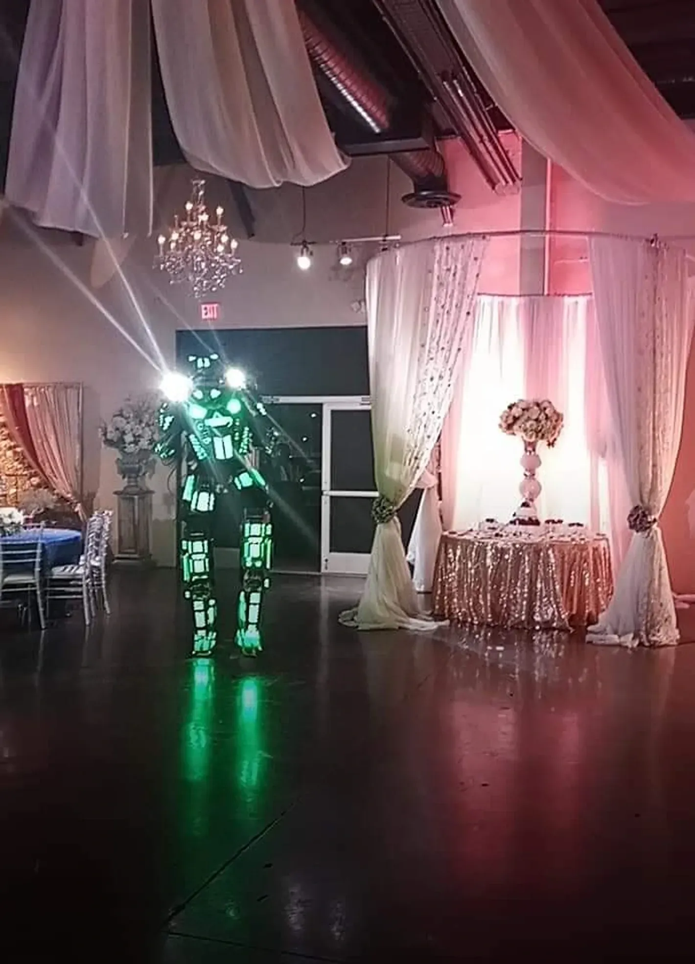 Event venue featuring dramatic ceiling drapery, elegant décor, sparkling chandeliers, and illuminate 