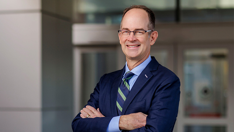 Male doctor smiling in a medical office setting.