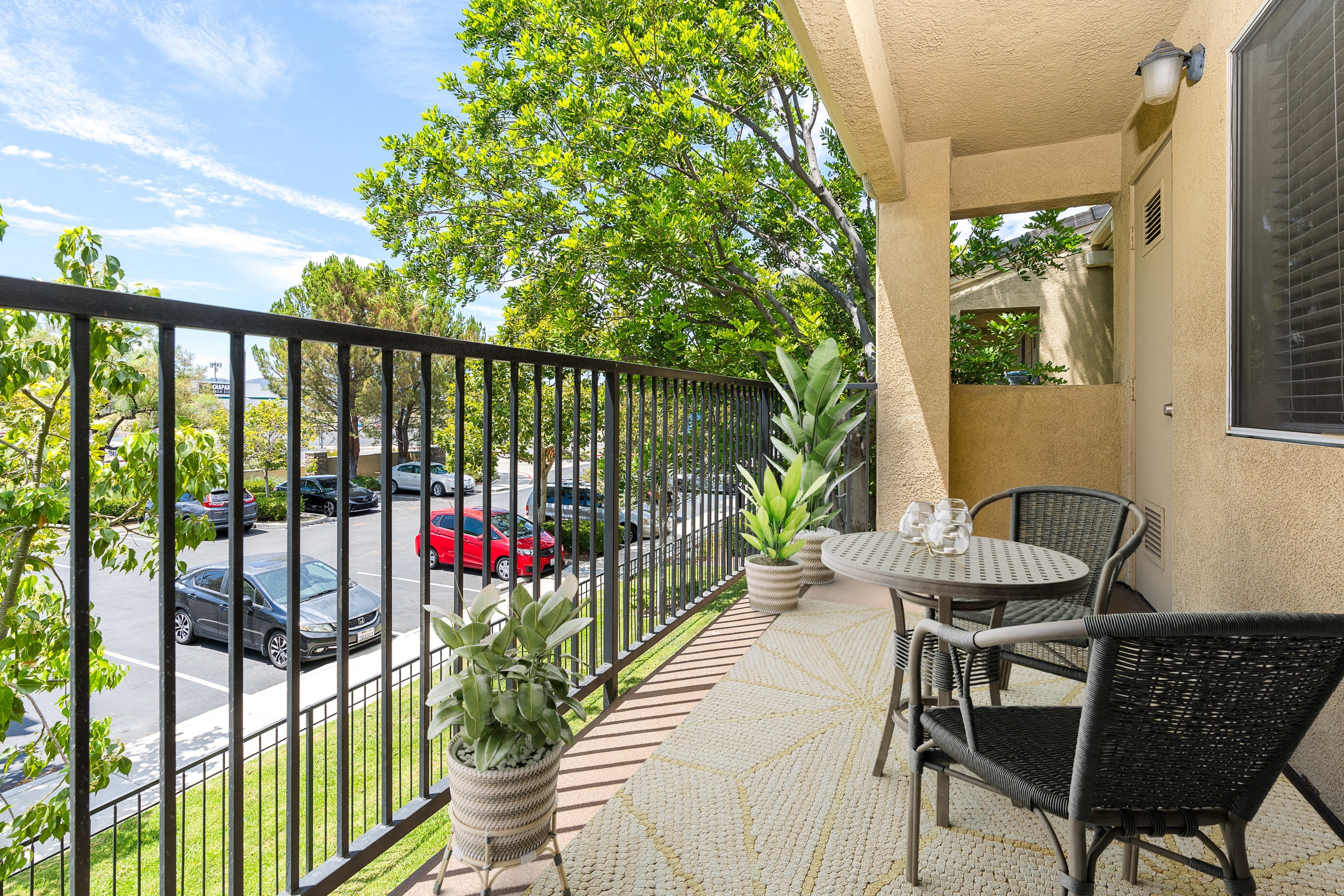 an apartment balcony with a table and chairs and a fence 
